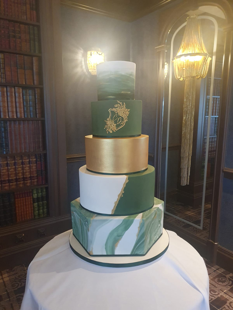 Five-tier white gold and green cake with hexagonal bottom tier and marble effect
